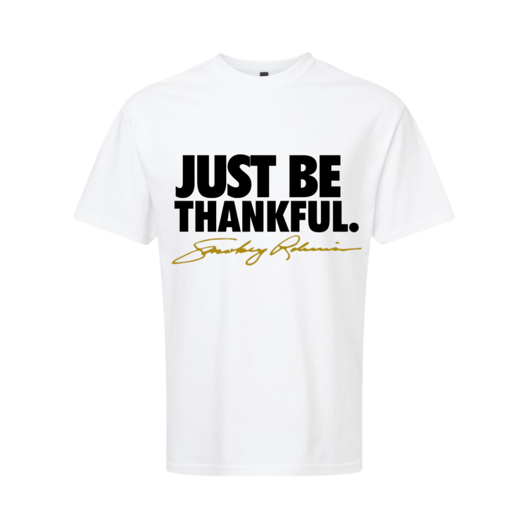White t-shirt with 'JUST BE THANKFUL' text and signature on a white background
